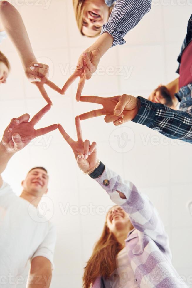 Making gesture by hands. Group of friends standing together photo