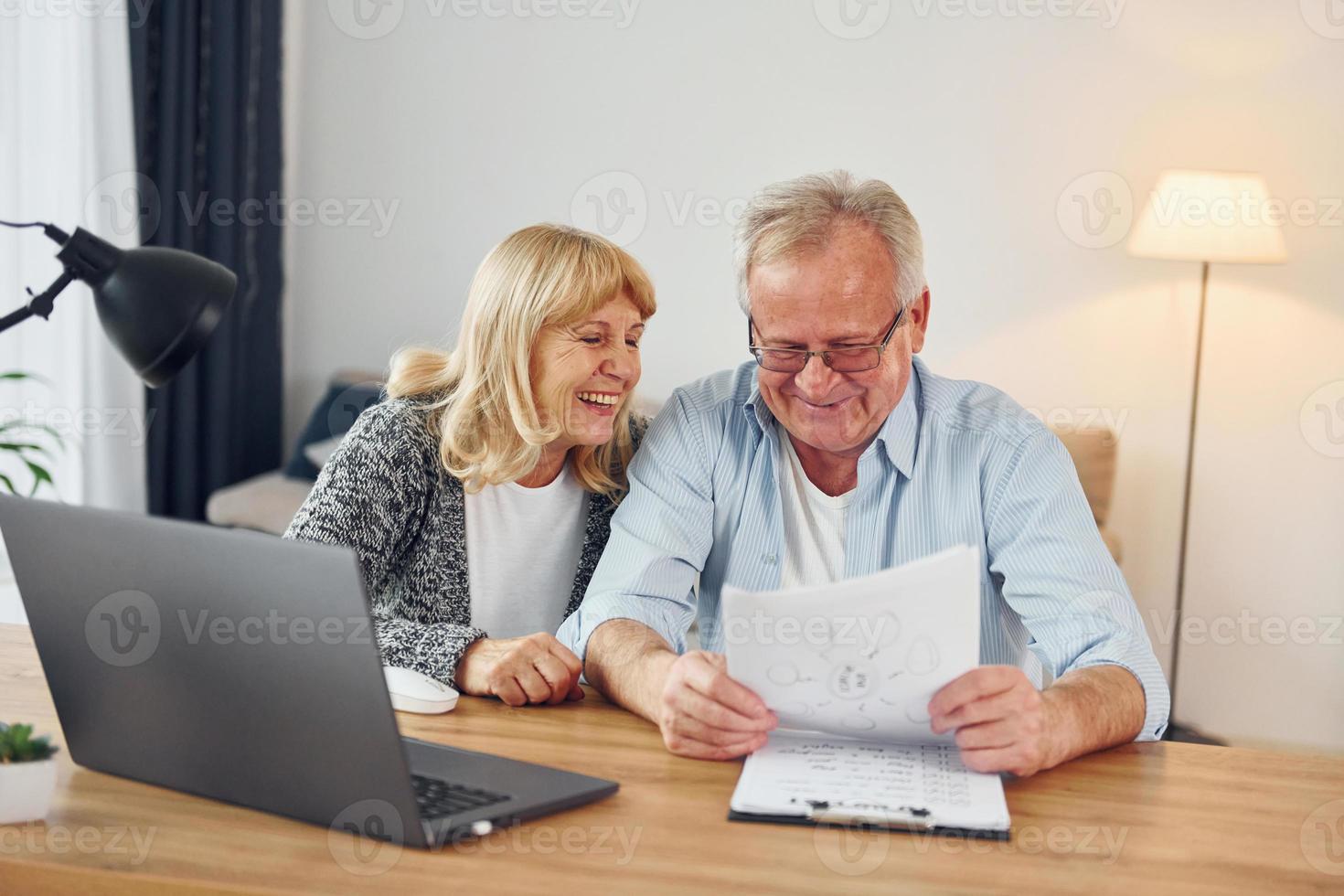 Using laptop. Senior man and woman is together at home photo