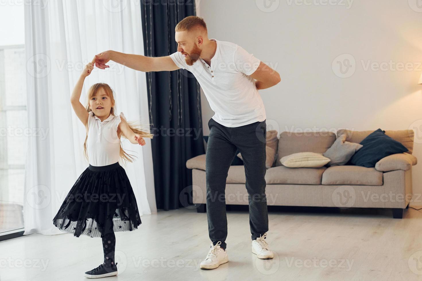 Learning to dance. Father with his little daughter is at home together photo