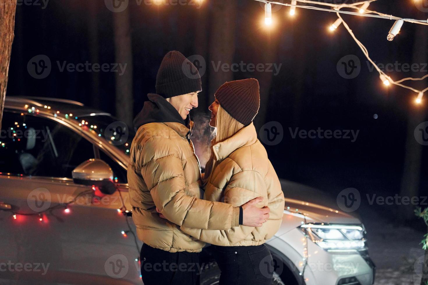 Looking at each other. Couple standing in the forest and celebrating New year photo