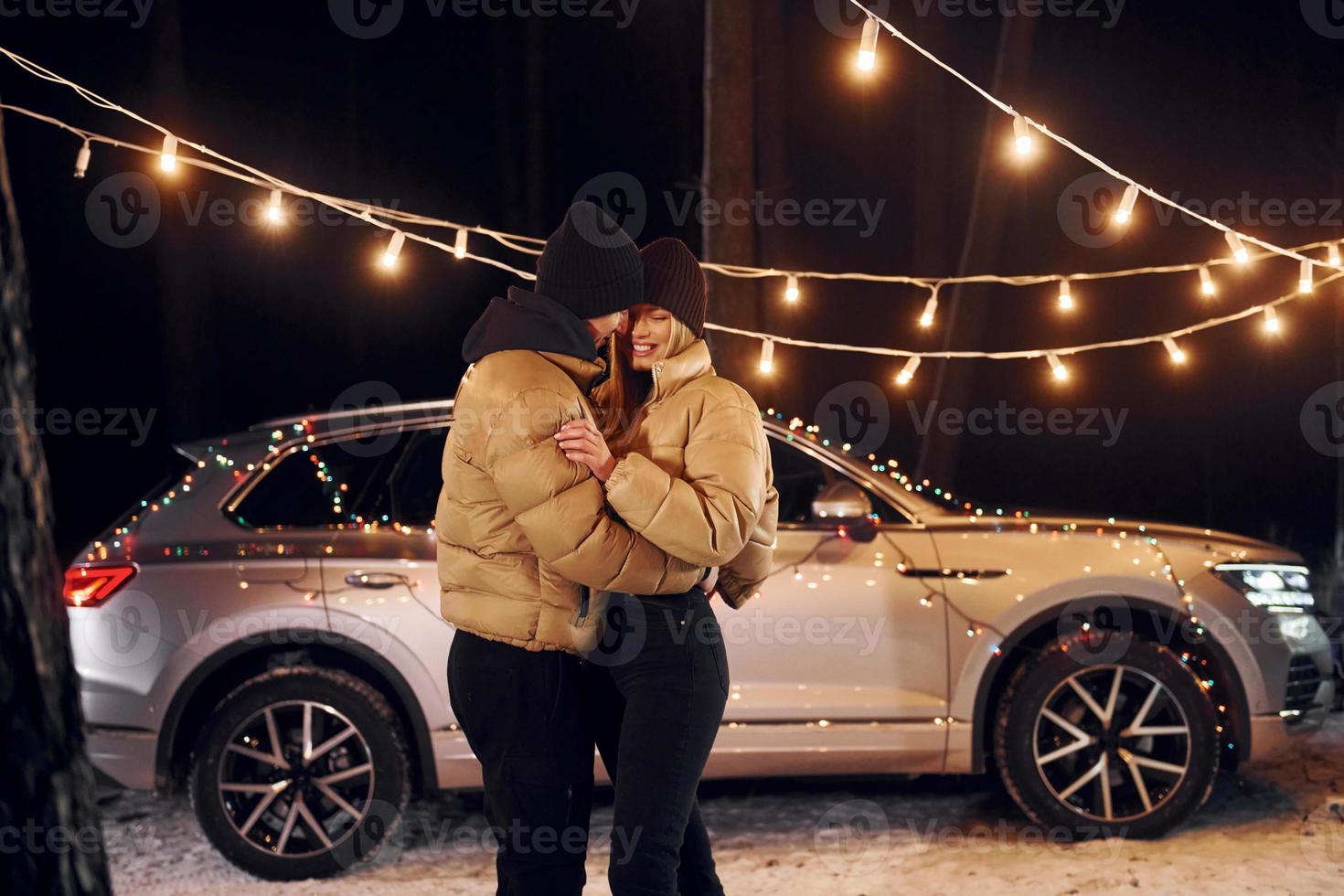 Holiday mood and decorations. Couple standing in the forest and celebrating New year photo