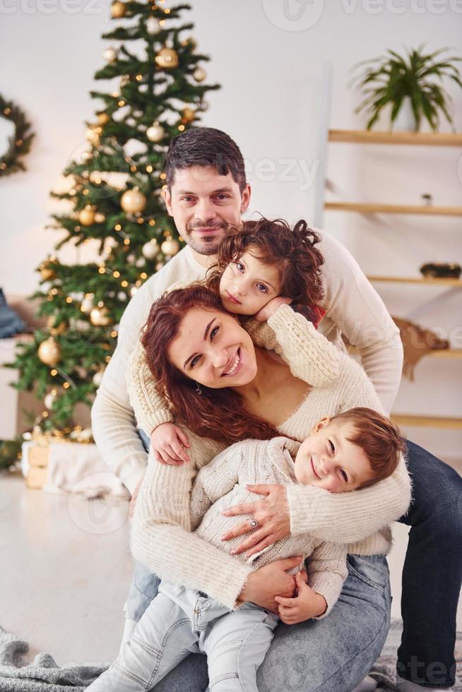 posando para la cámara. familia celebrando el año nuevo con sus hijos en casa foto