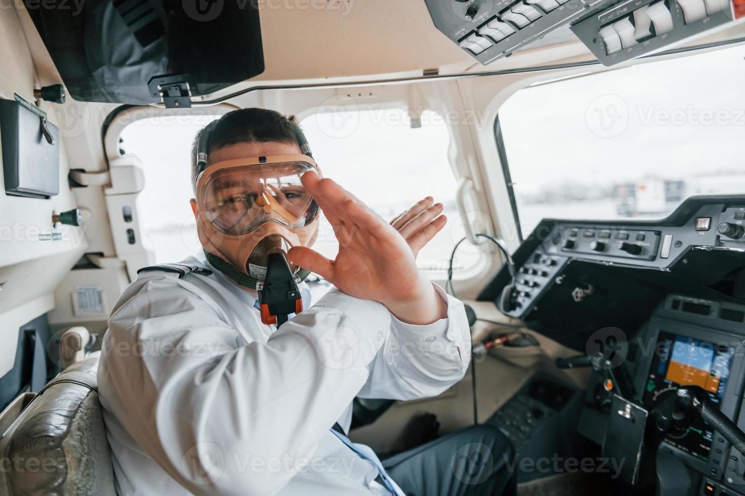 In oxygen mask. Pilot on the work in the passenger airplane. Preparing for takeoff photo