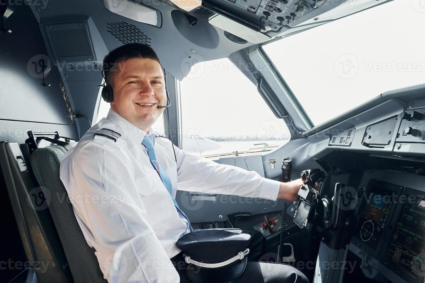 Side view. Pilot in formal wear sits in the cockpit and controls airplane photo