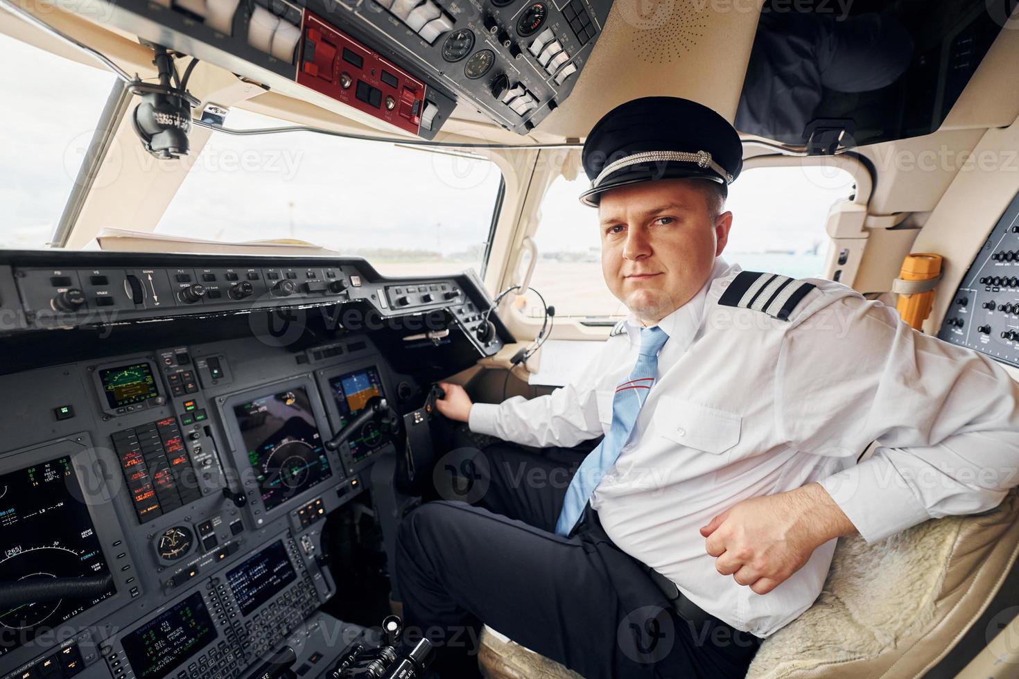 Professional worker. Pilot in formal wear sits in the cockpit and controls airplane photo