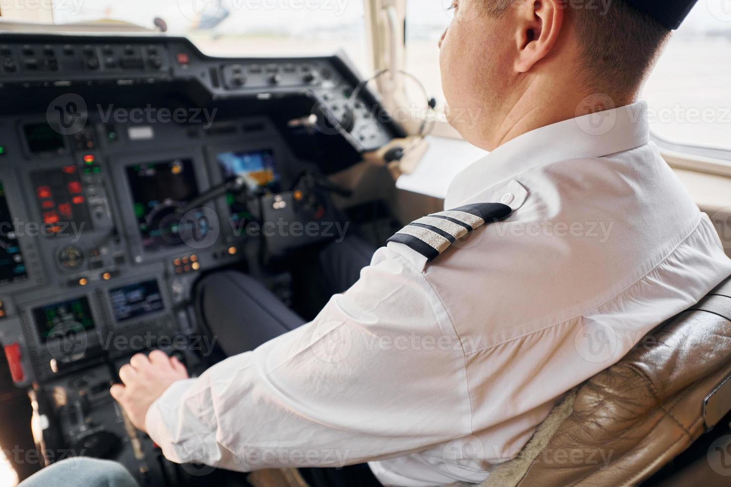 Calm atmosphere. Pilot in formal wear sits in the cockpit and controls airplane photo