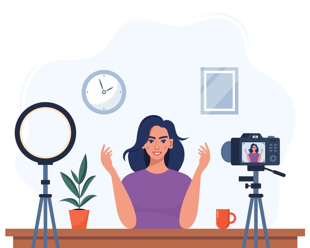 Woman blogger records herself on video using a camera and a circle light lamp. Vector character influencer creating a video review for a blog. Vlogger records video indoors. Flat illustration.