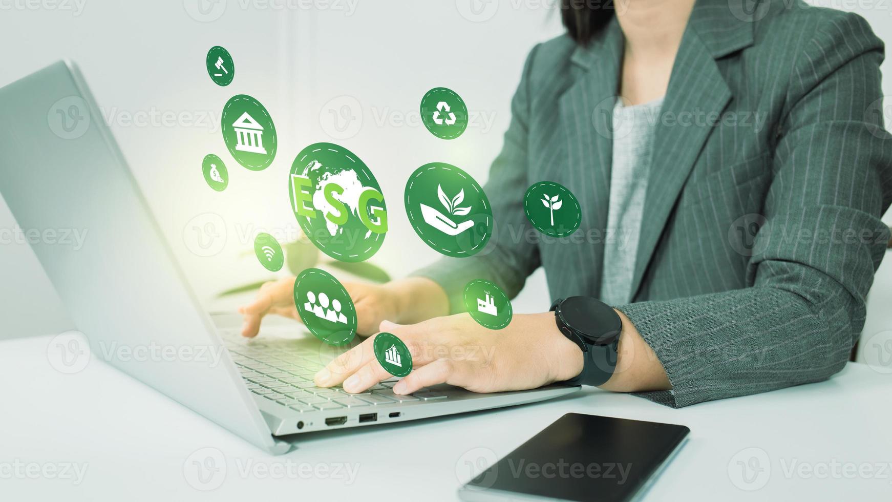 ESG environment social governance investment business concept. Women use a computer to analyze ESG, surrounded by ESG icons .close to the computer screen in business investment strategy concept. photo
