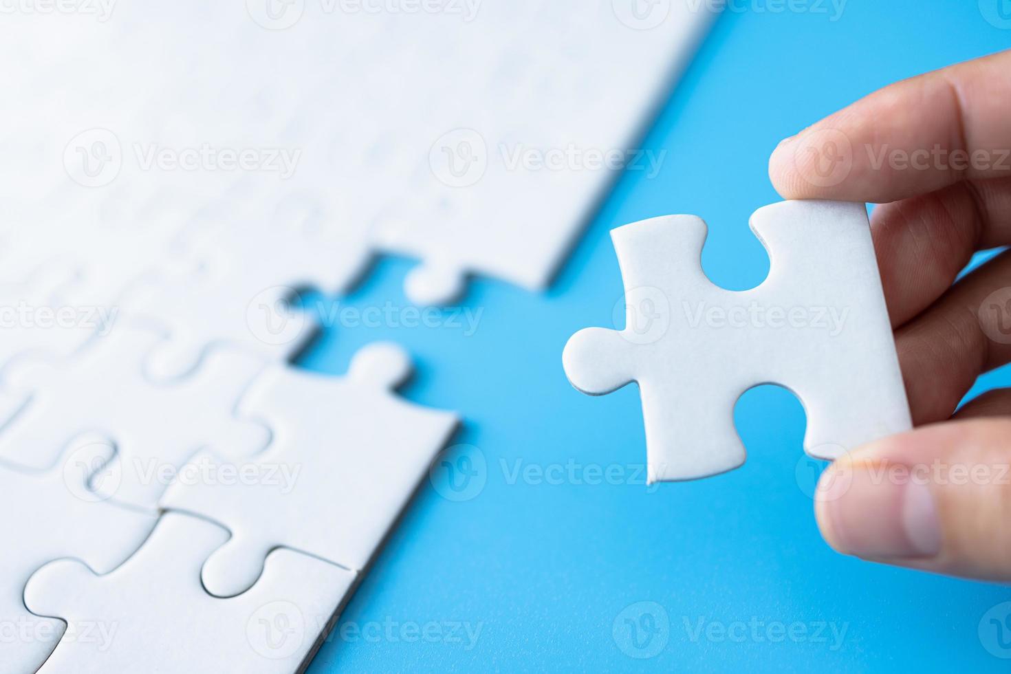 Closeup hand of woman connecting jigsaw puzzle, Business solutions, success and strategy concept. photo