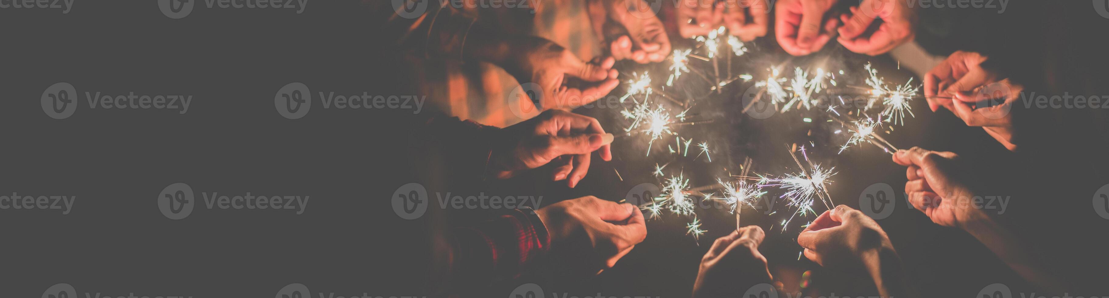 Group of young friends enjoy with burning sparkler in hands together photo