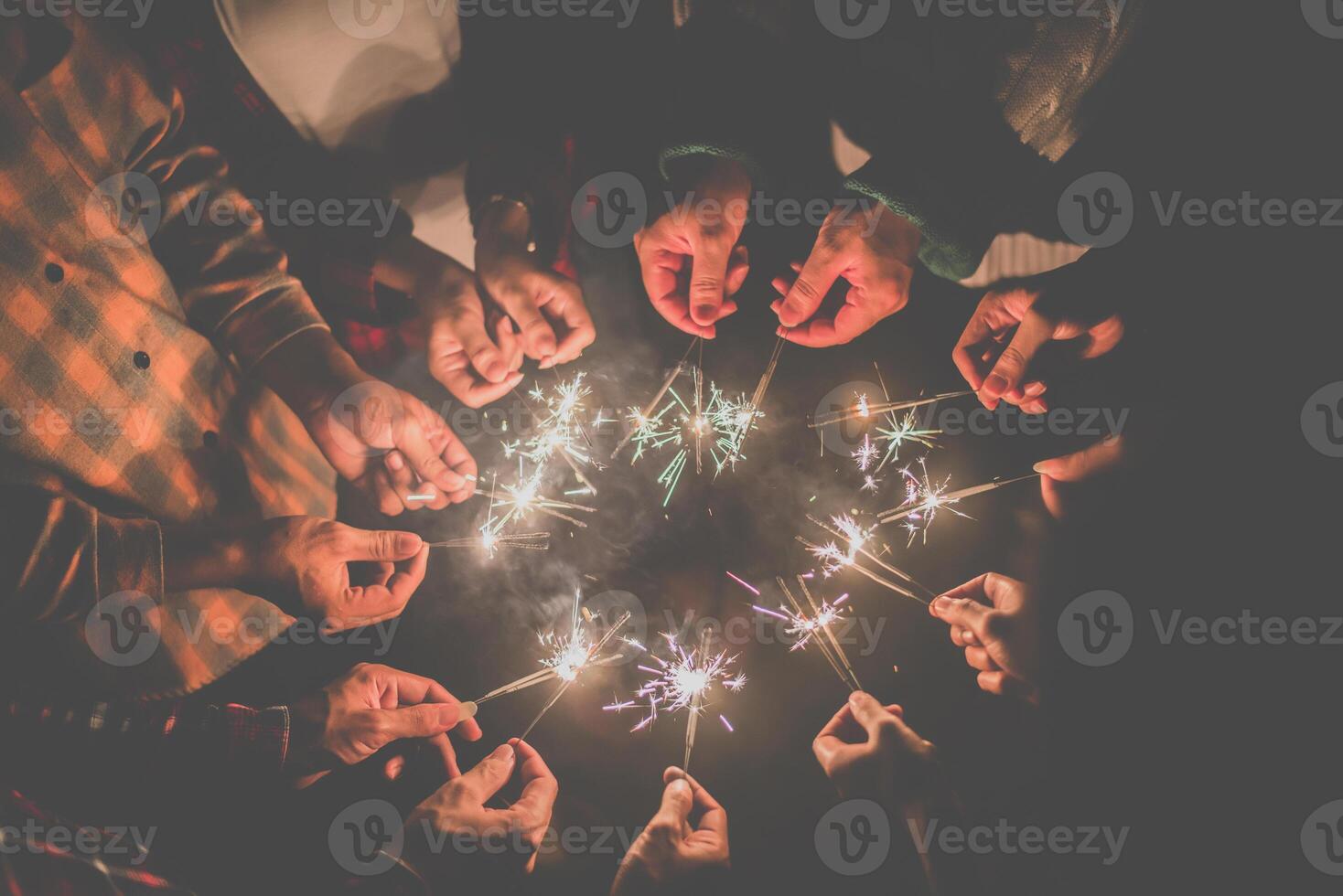 Group of young friends enjoy with burning sparkler in hands together photo