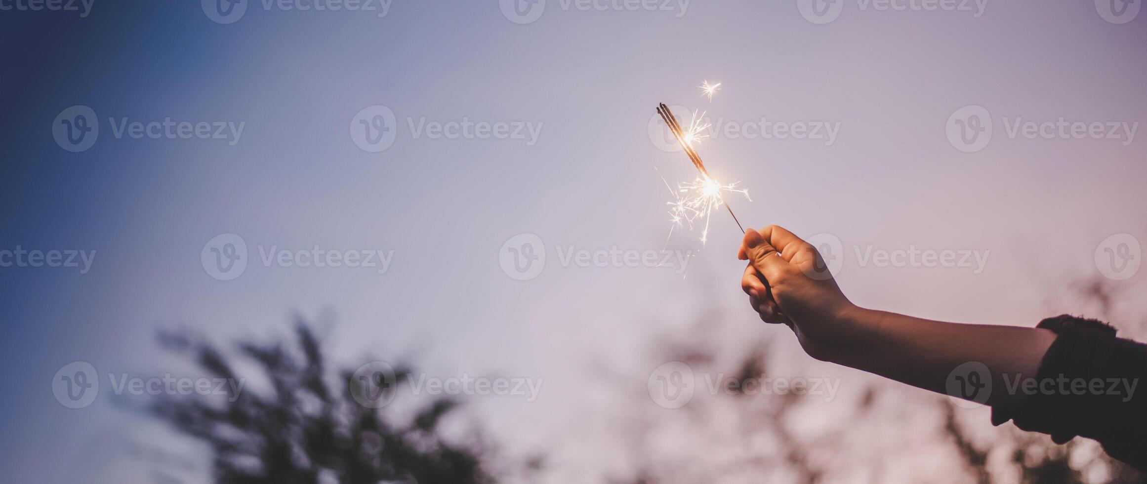 mano femenina disfruta con una explosión de bengala ardiente en la fiesta de año nuevo foto