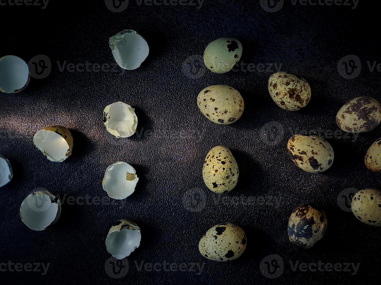 huevos de codorniz de codorniz, una colección de huevos de codorniz en un plato de madera con fondo de arena negra foto