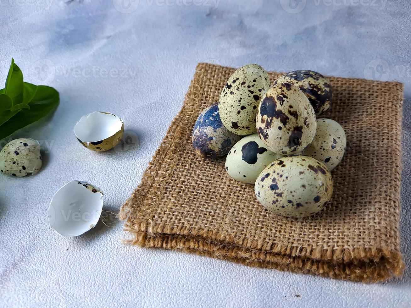 Quail eggs from quail, a collection of quail eggs on a wooden plate against a white wall background photo