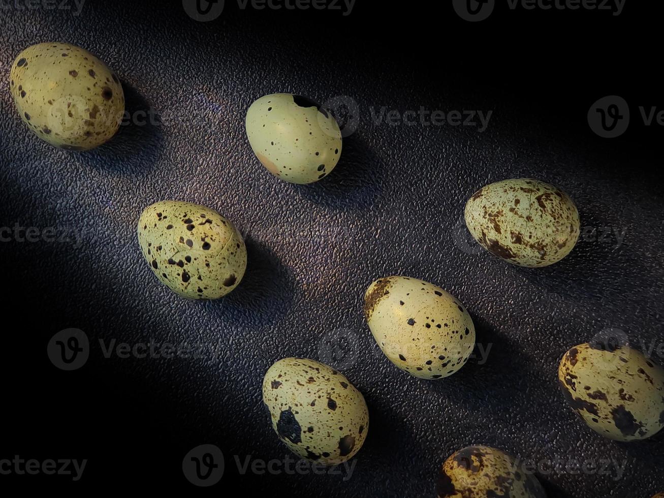 Quail eggs from quail, a collection of quail eggs on a wooden plate with a black sand background photo