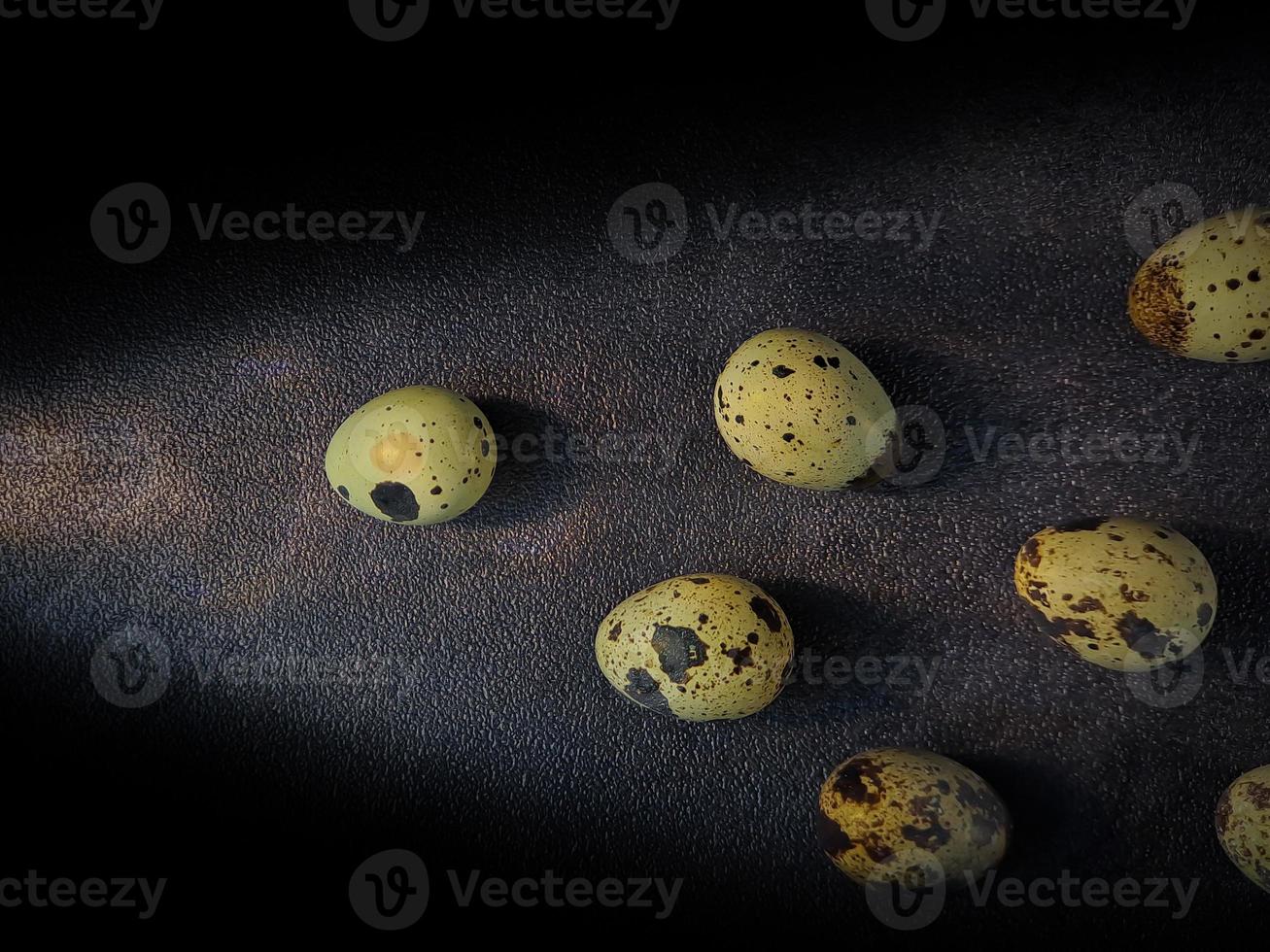 Quail eggs from quail, a collection of quail eggs on a wooden plate with a black sand background photo