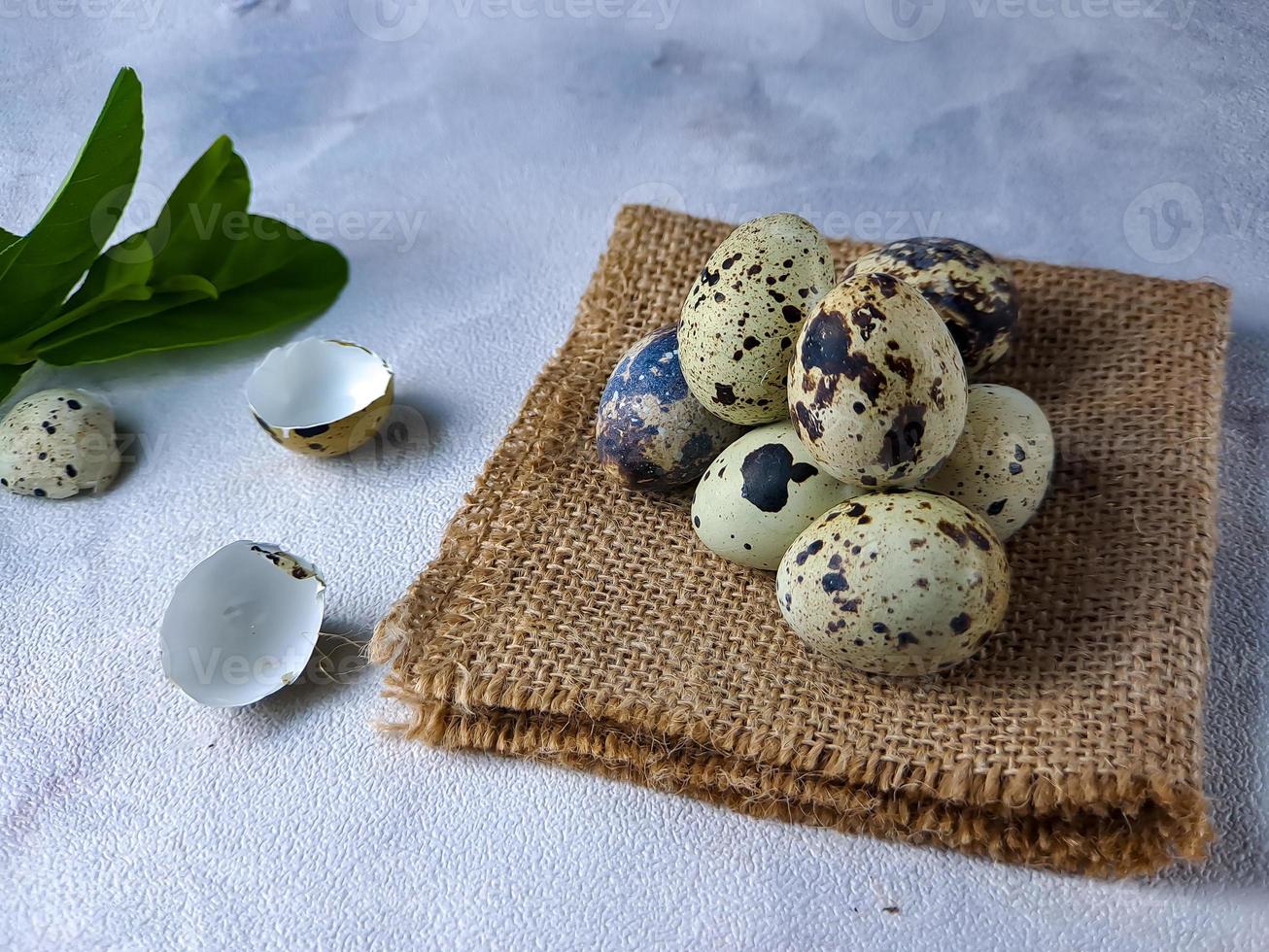 Quail eggs from quail, a collection of quail eggs on a wooden plate against a white wall background photo