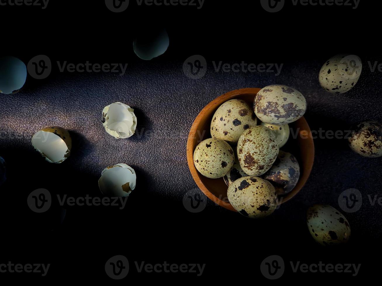 Quail eggs from quail, a collection of quail eggs on a wooden plate with a black sand background photo