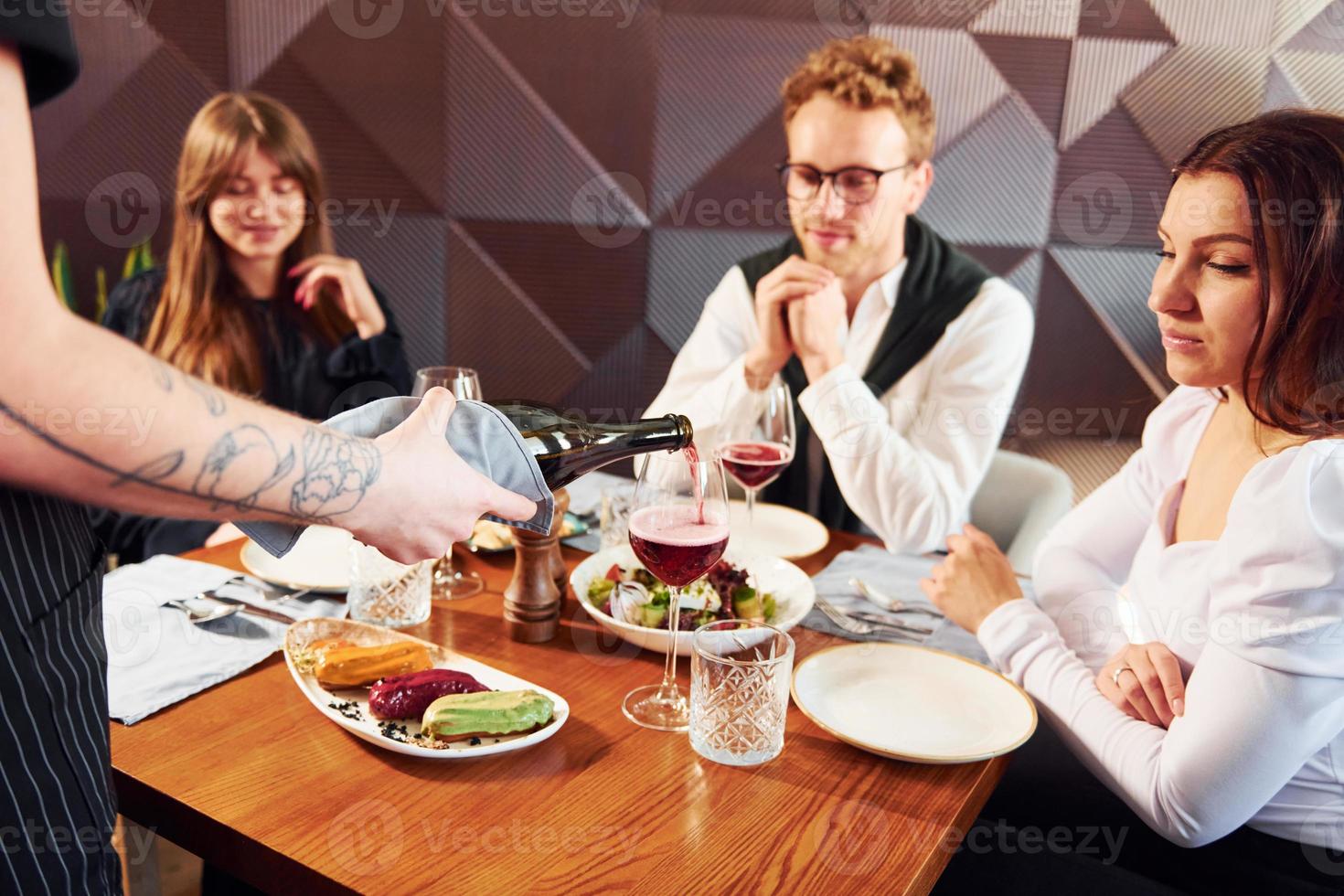 People have a dinner together. Indoors of new modern luxury restaurant photo