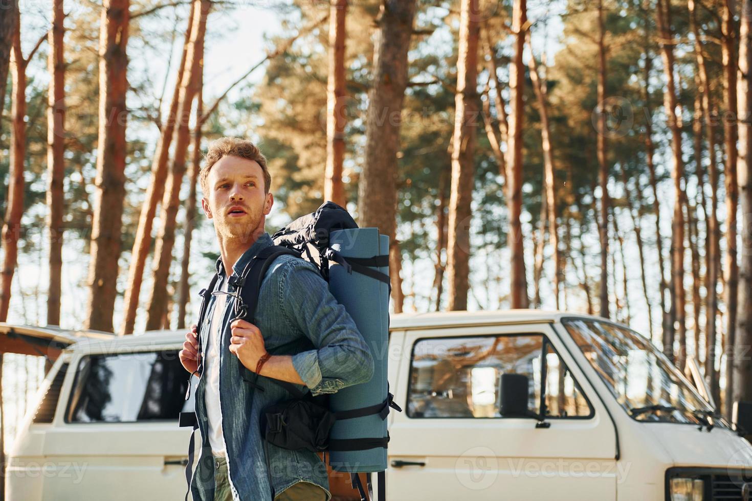 Near car and camp. Man is traveling alone in the forest at daytime at summer photo