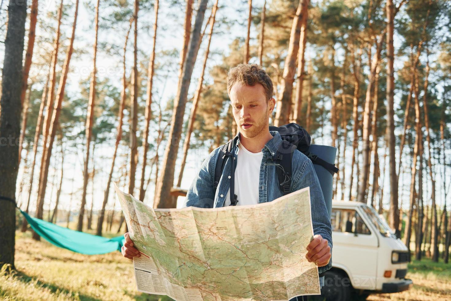 utiliza el mapa. el hombre viaja solo en el bosque durante el día en verano foto