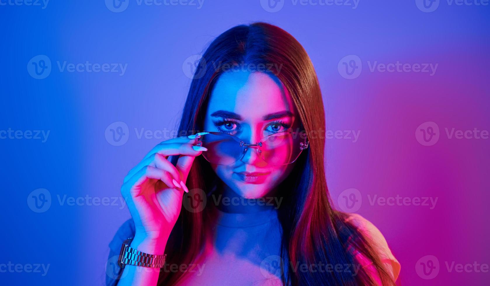 joven de moda parada en el estudio con luz de neón foto