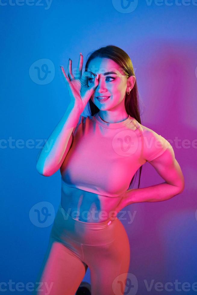 cuerpo delgado. joven de moda parada en el estudio con luz de neón foto