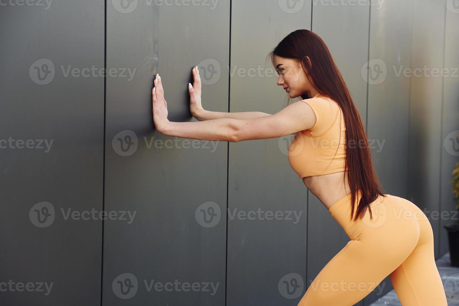 Side view. Young woman in sportswear have fitness session outdoors photo