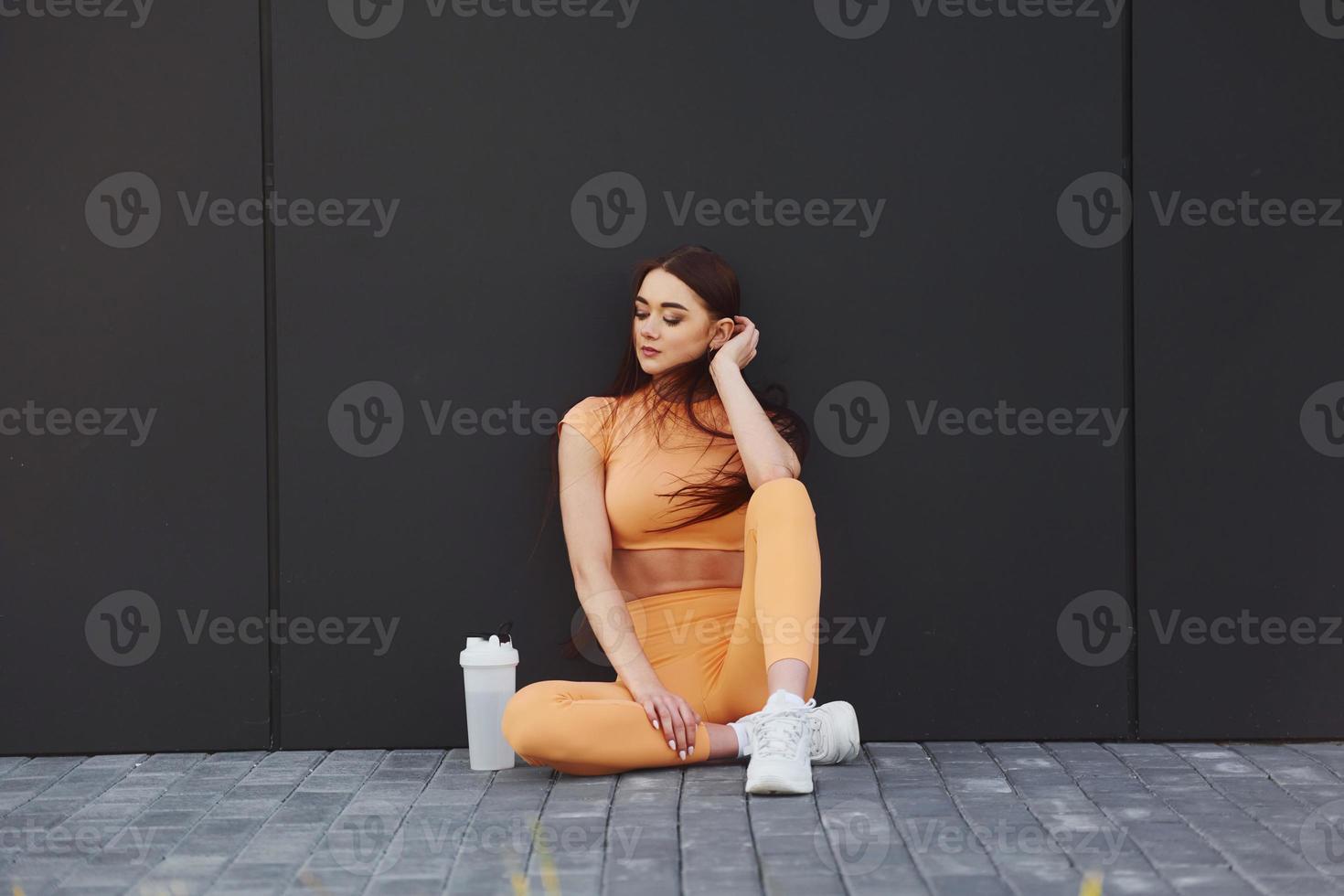 Sits and takes a rest. Young woman in sportswear have fitness session outdoors photo