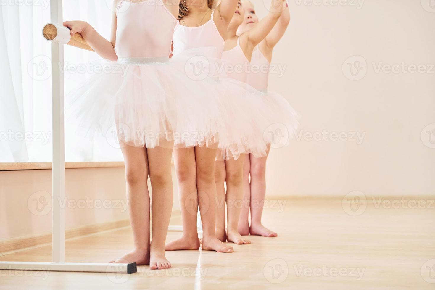 Close up view. Little ballerinas preparing for performance by practicing dance moves photo