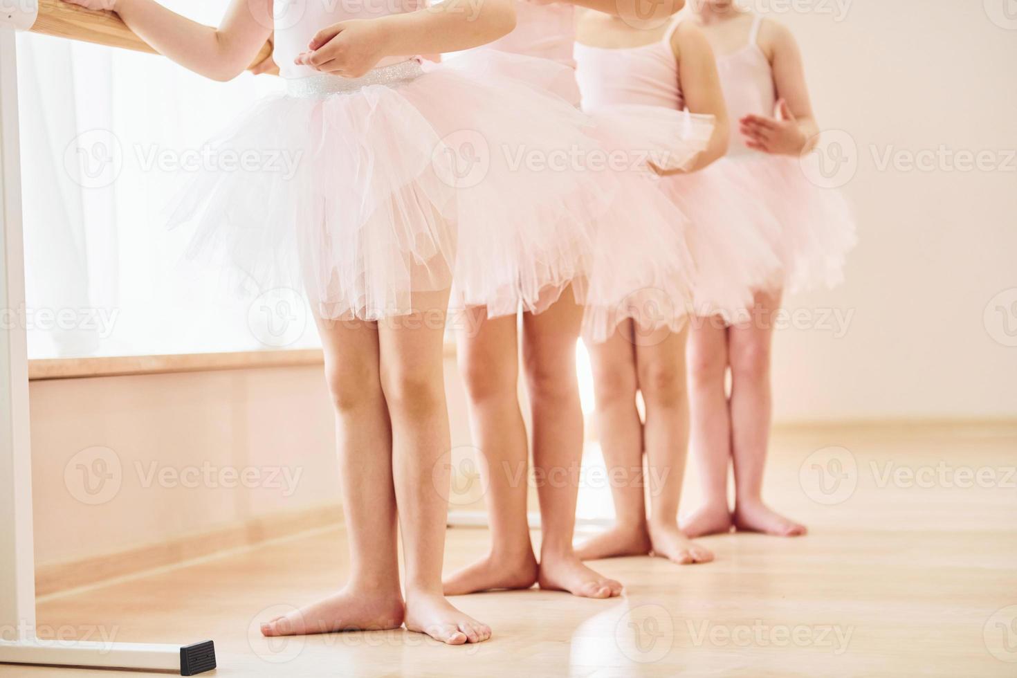 Close up view. Little ballerinas preparing for performance by practicing dance moves photo