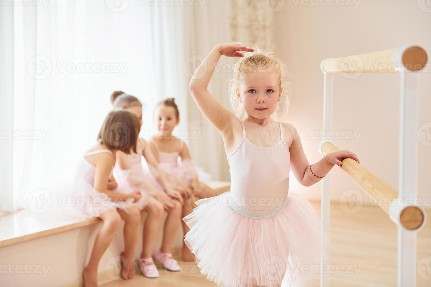 Little ballerinas in pink uniforms preparing for performance photo