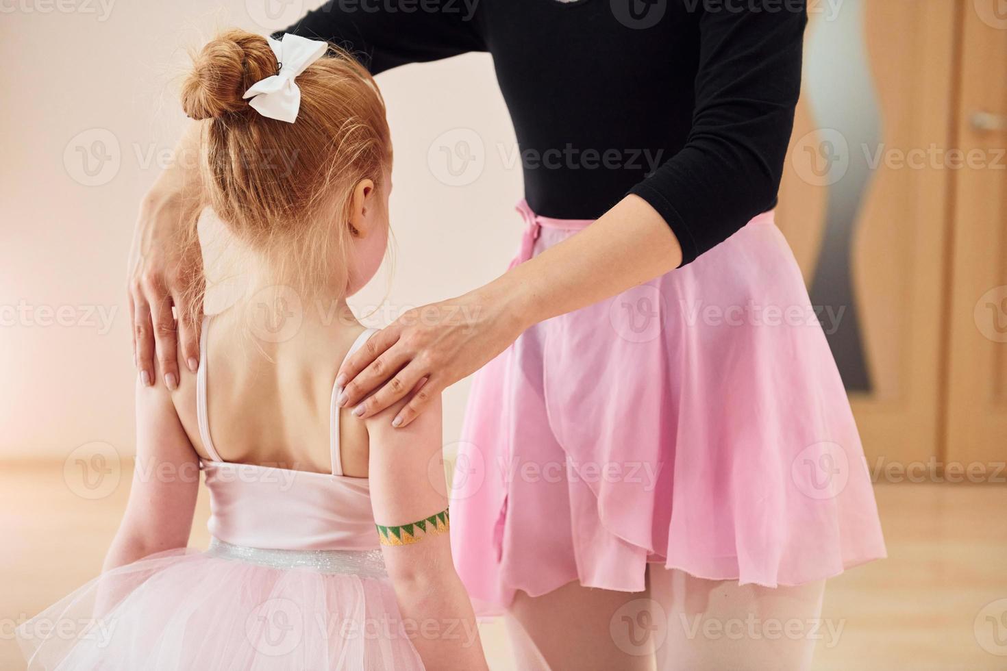 postura de fijación. pequeñas bailarinas preparándose para la actuación practicando movimientos de baile foto