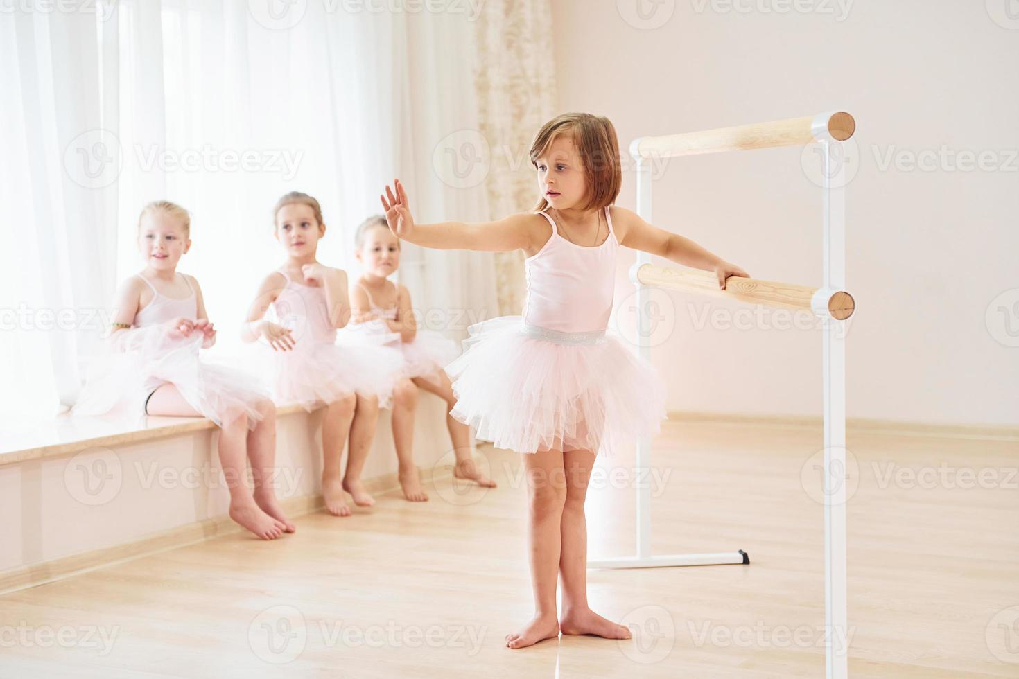 Practicing dance moves. Little ballerinas preparing for performance photo