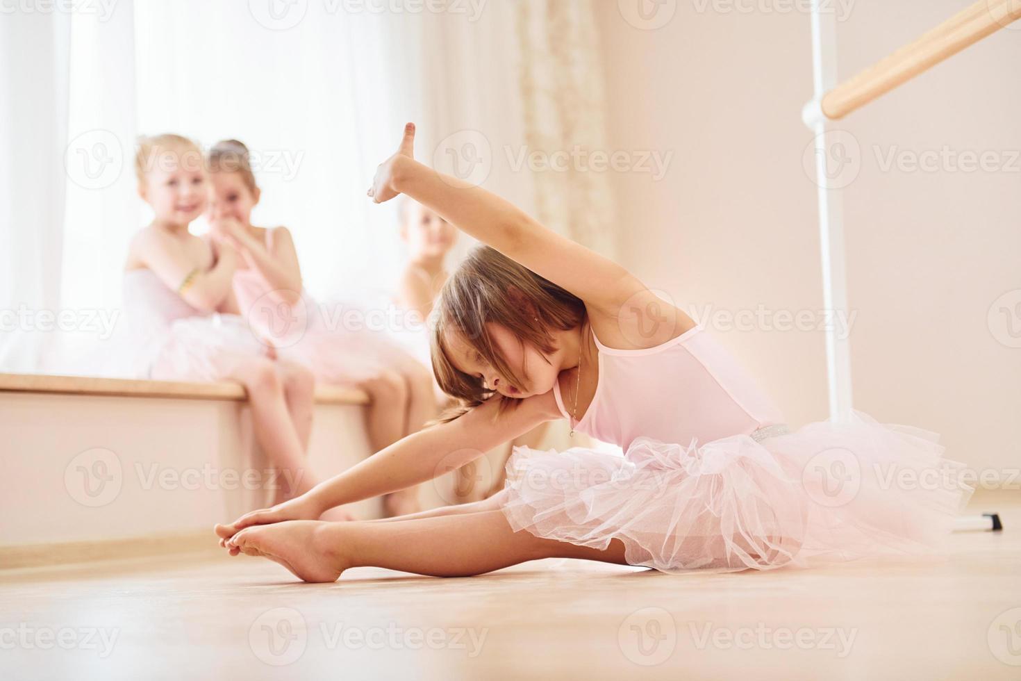 Practicing on the floor. Little ballerinas preparing for performance photo