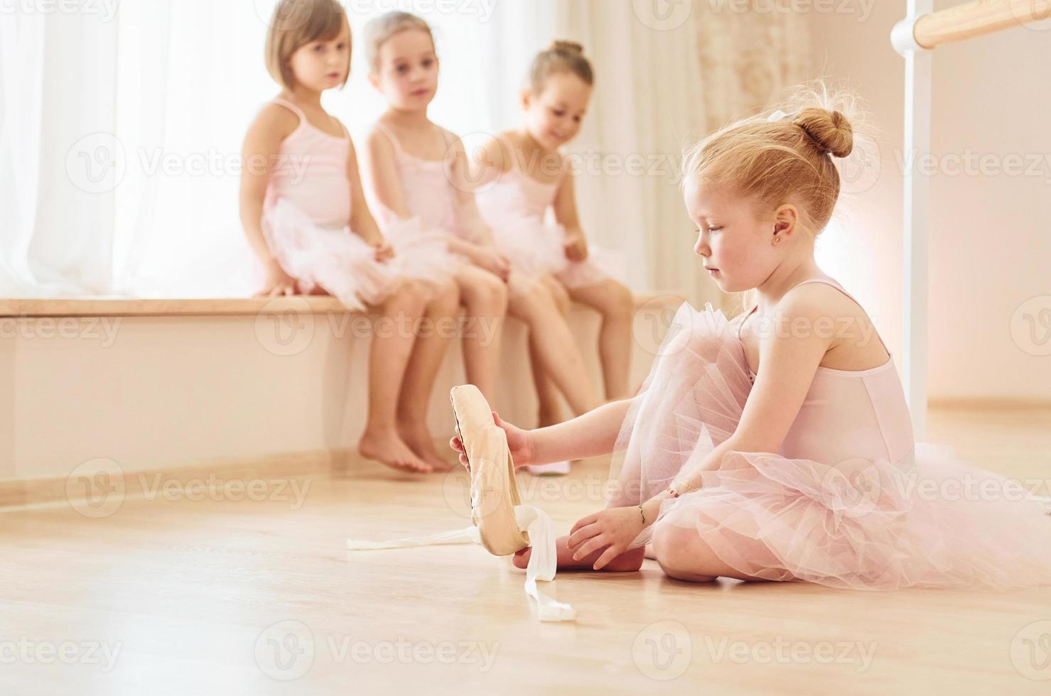 Little ballerinas in pink uniforms preparing for performance photo