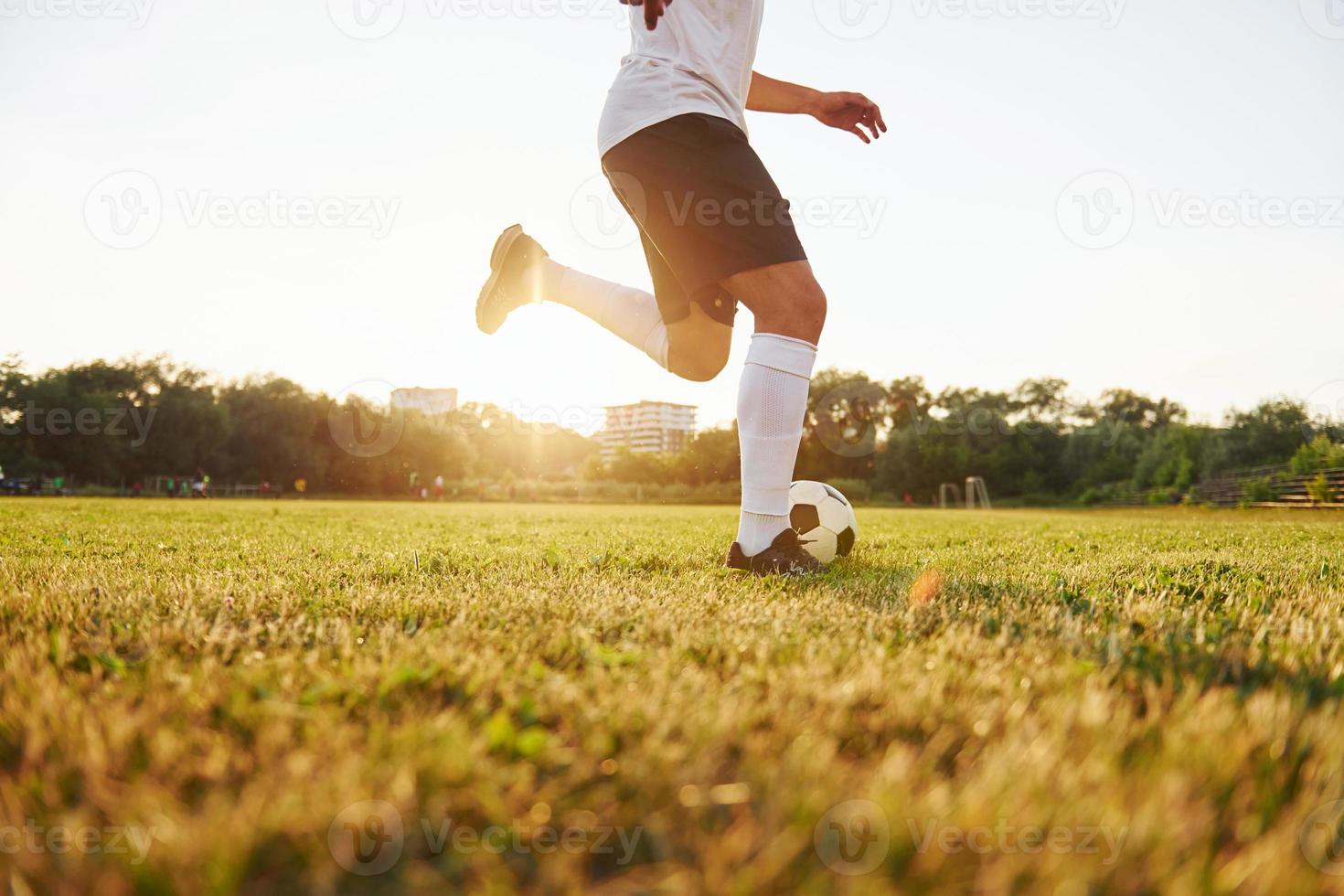 Runs with ball. Young soccer player have training on the sportive field photo