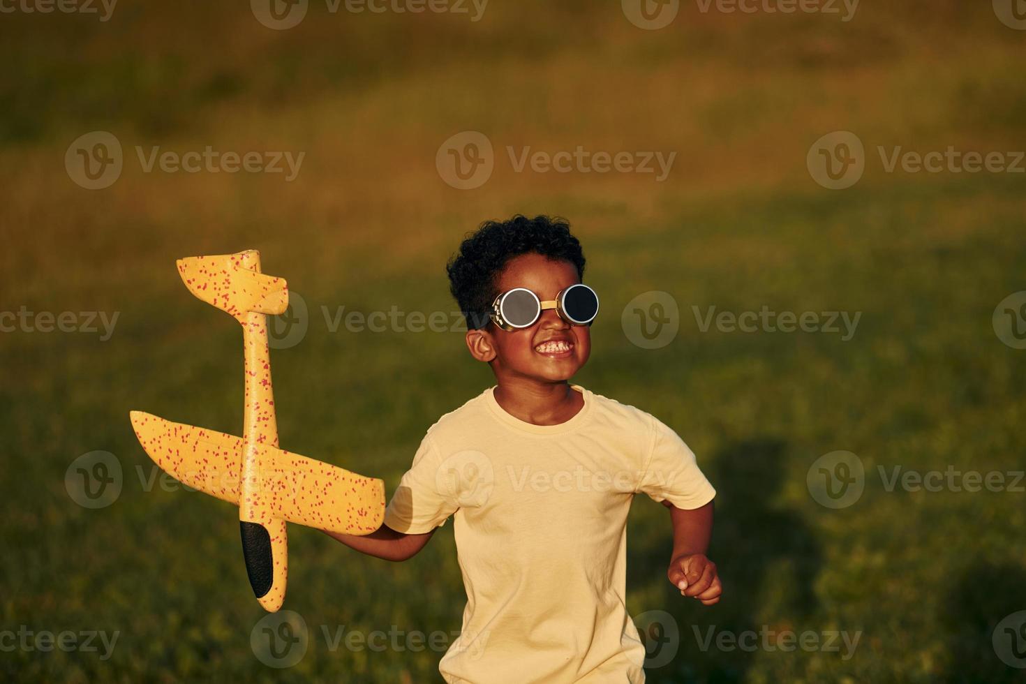 Weekend activities. African american kid have fun in the field at summer daytime photo