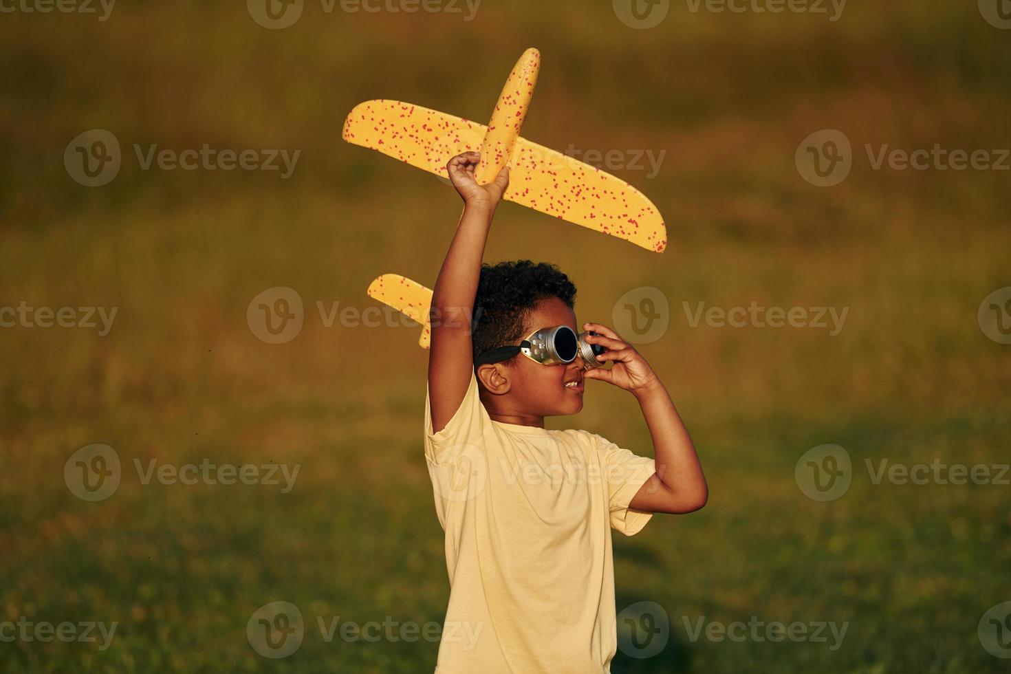 Weekend activities. African american kid have fun in the field at summer daytime photo