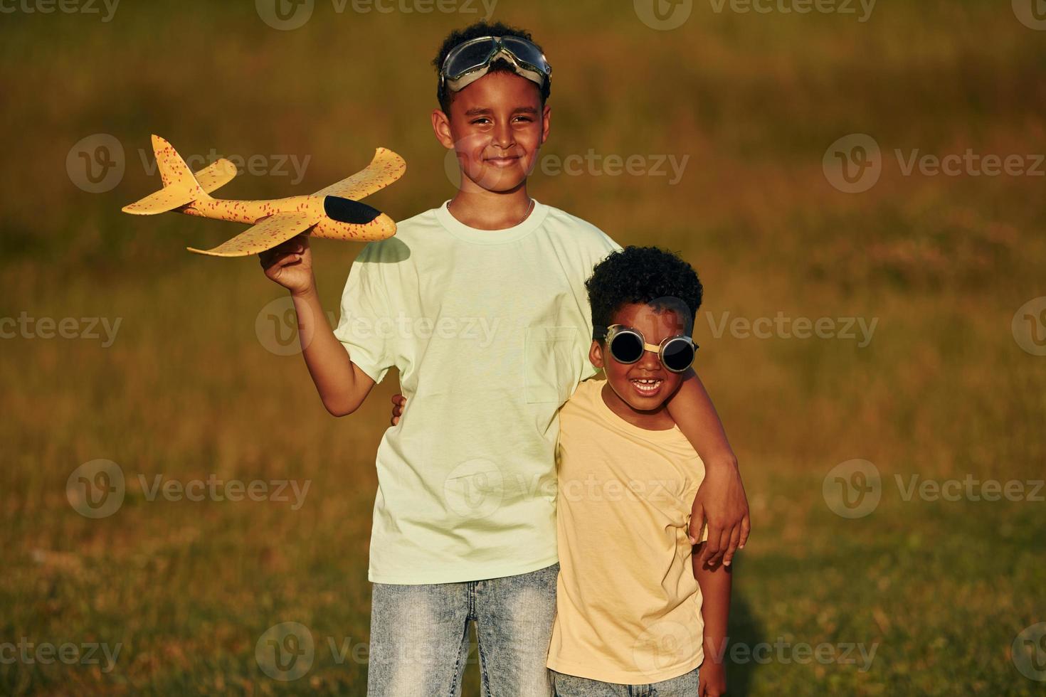 en verano durante el día juntos. dos niños afroamericanos se divierten en el campo foto