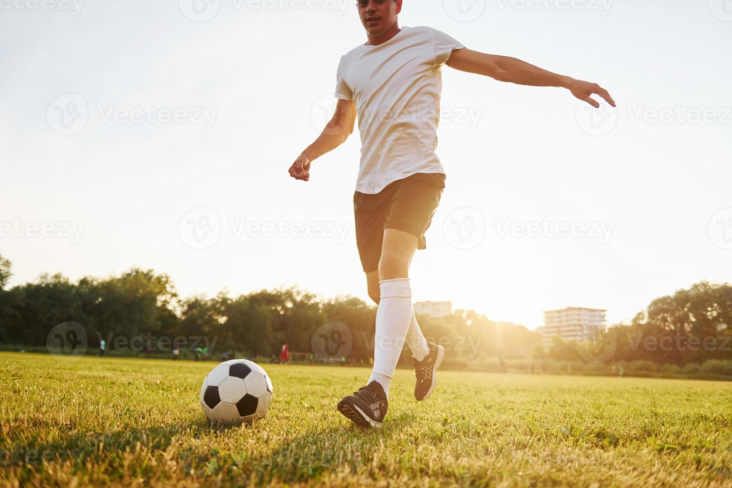 Runs with ball. Young soccer player have training on the sportive field photo