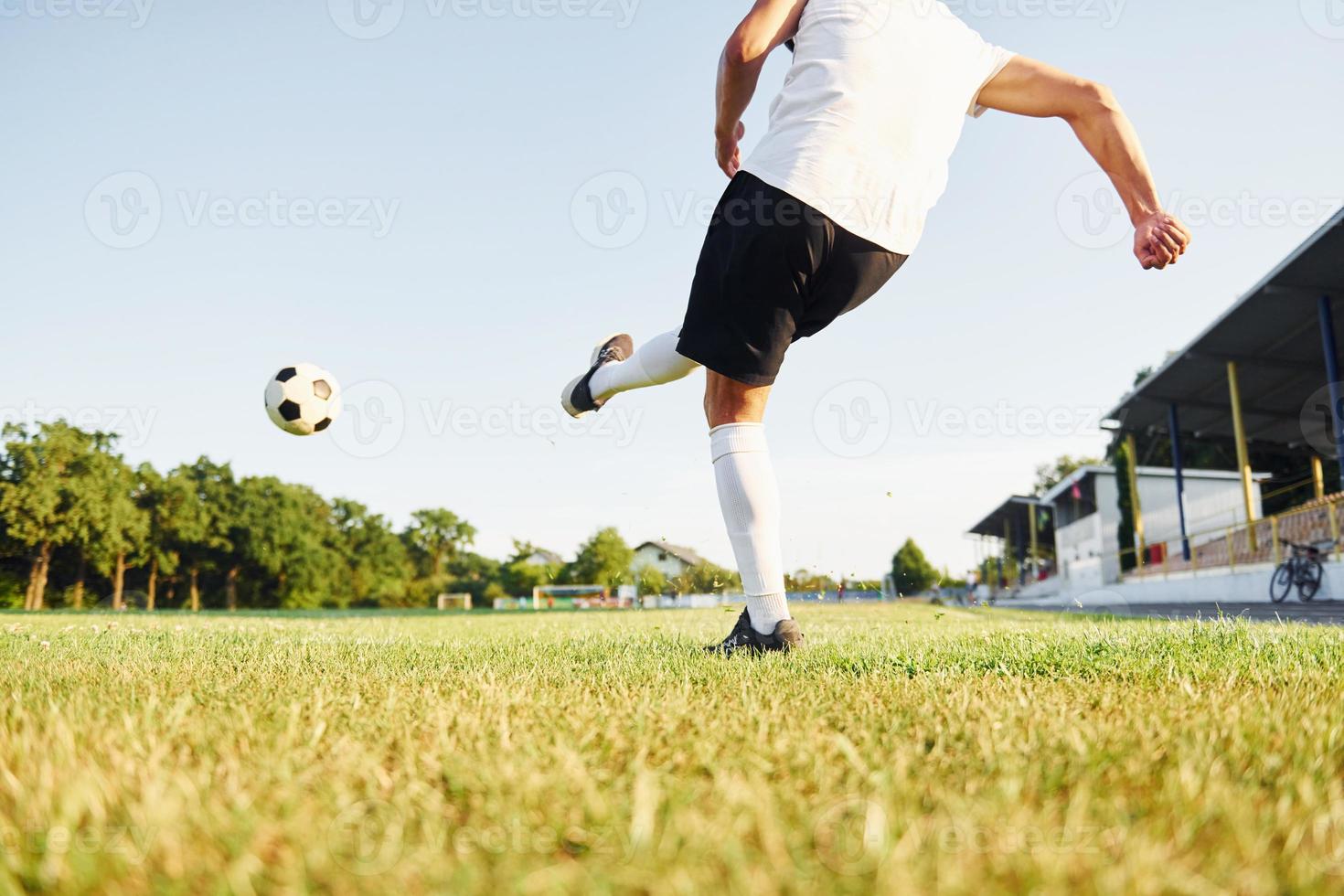 patea la pelota. el joven futbolista tiene entrenamiento en el campo deportivo foto