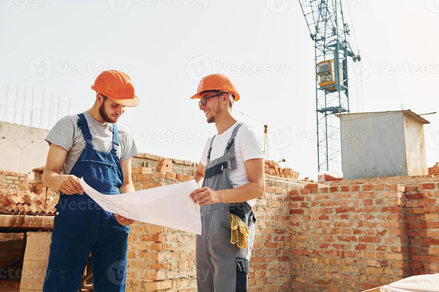 con documentos dos trabajadores de la construcción están juntos en el edificio foto