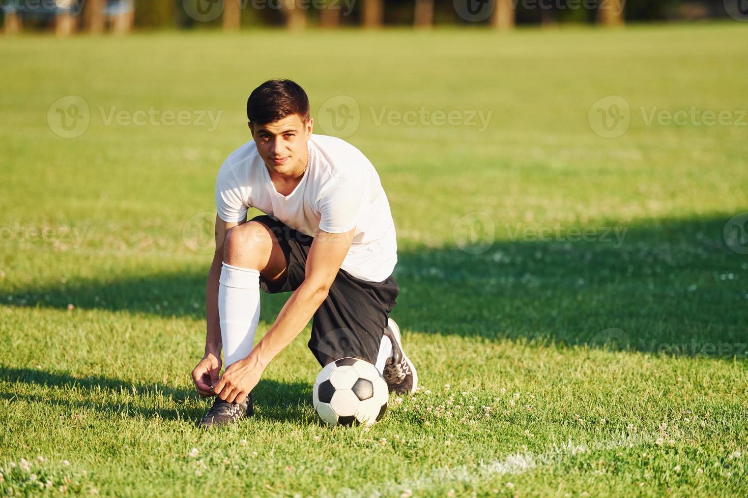 Preparing for the game. Young soccer player have training on the sportive field photo