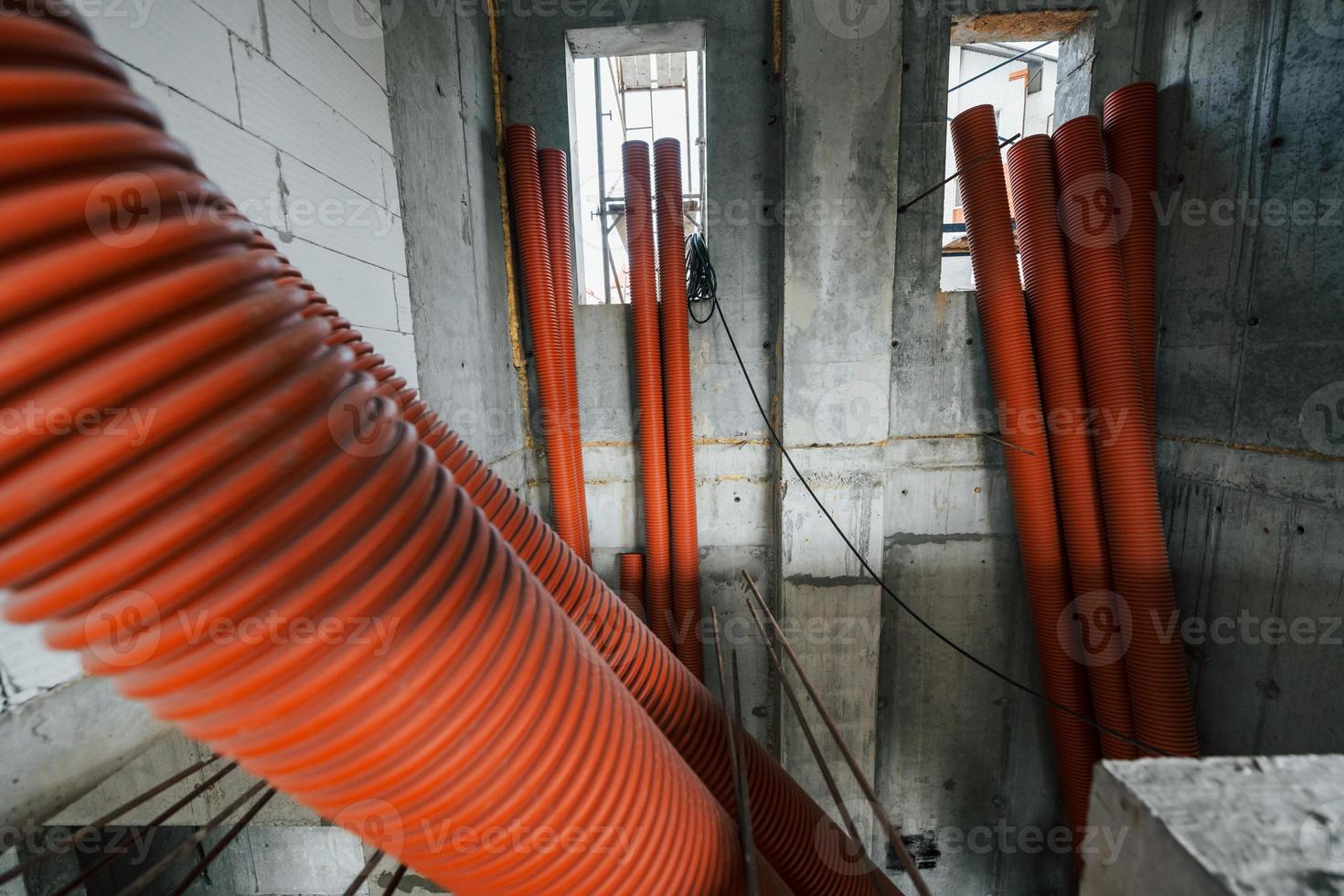 Inside of the unfinished building. Orange colored pipes photo