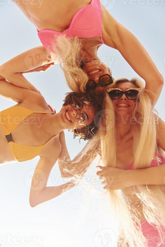 View from below. Women in swimsuits have fun outdoors together at summertime photo