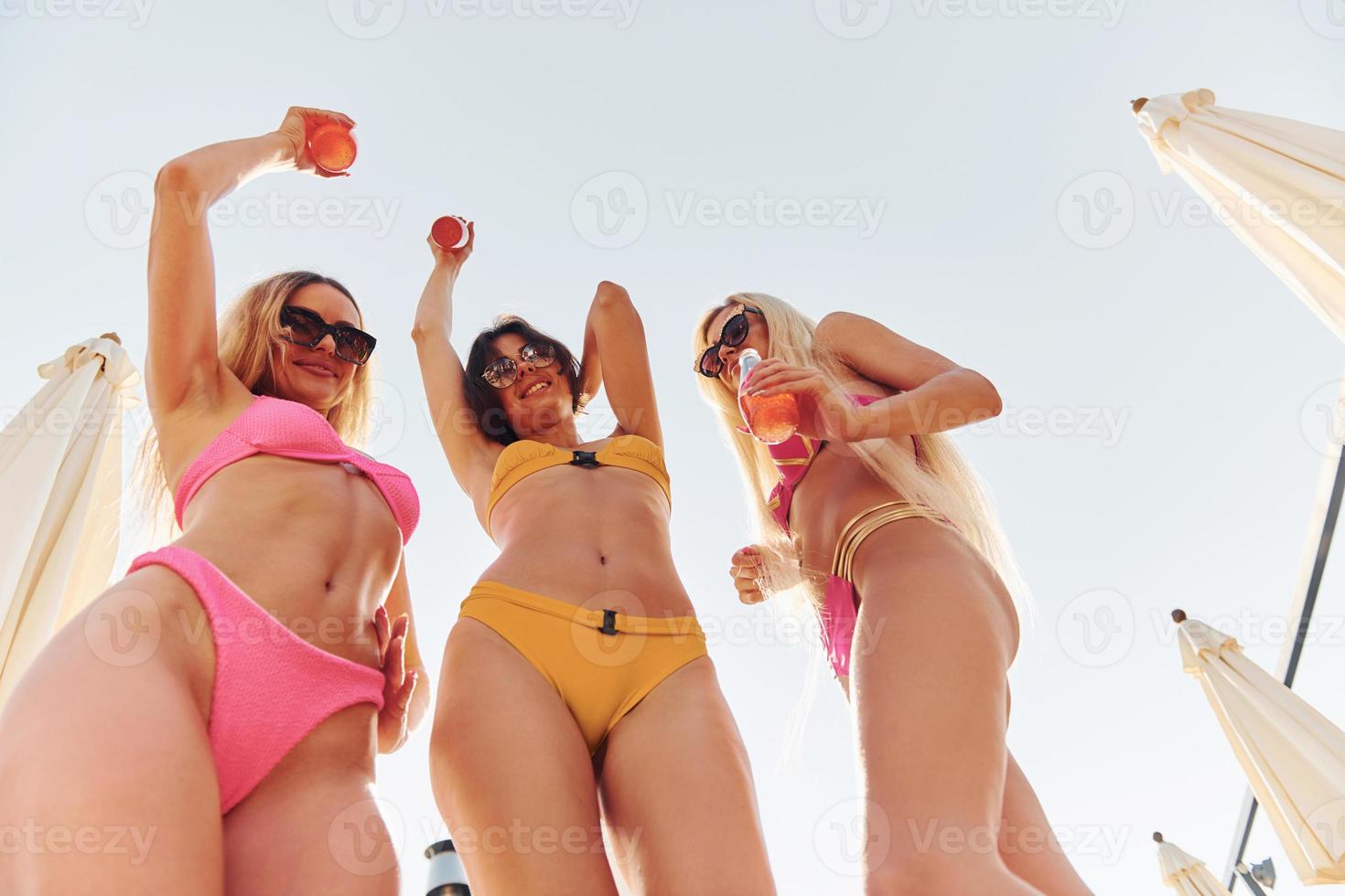 Women in swimsuits have fun outdoors together at summertime photo