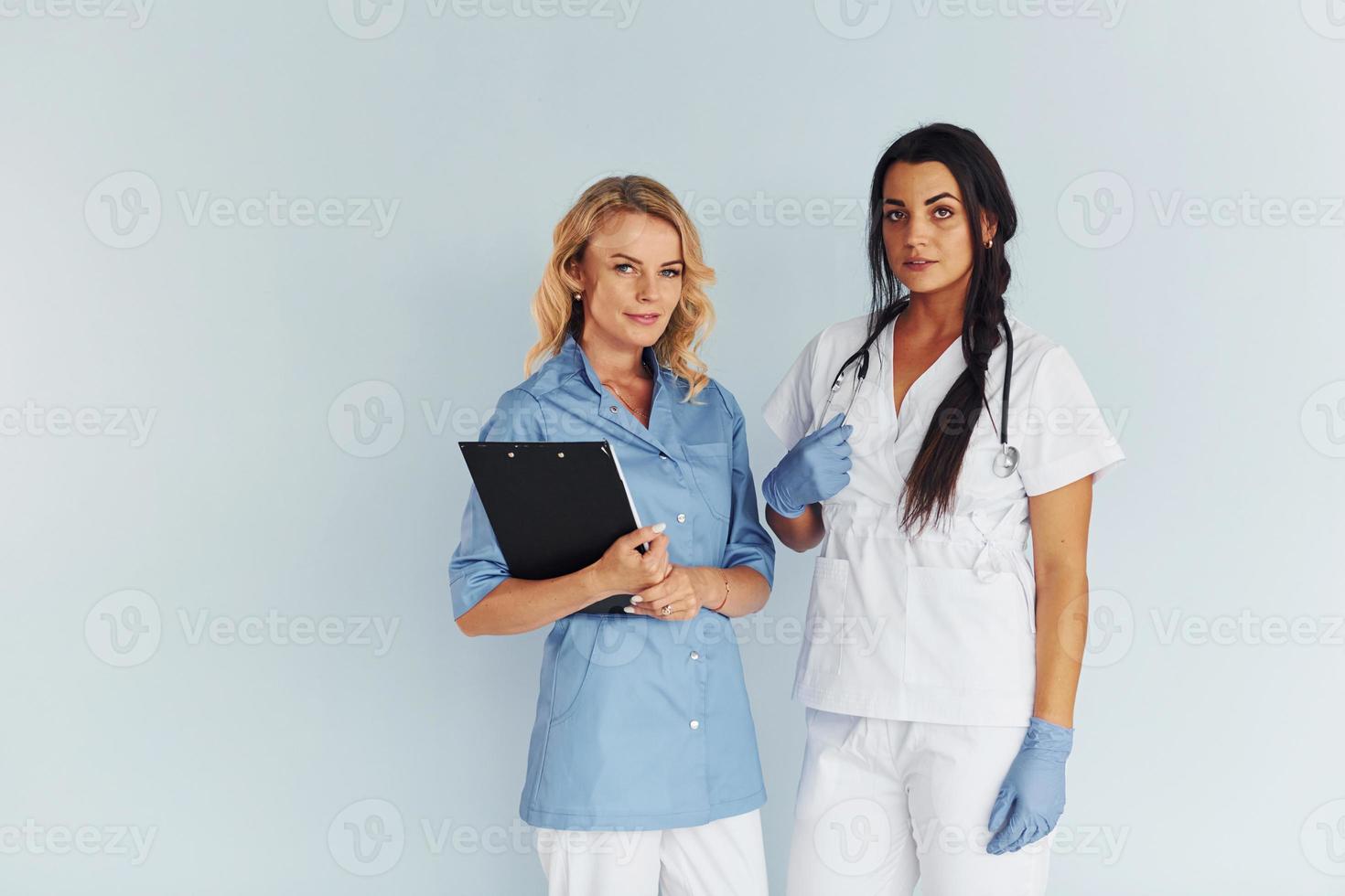 Two doctors in uniform standing indoors and working together photo