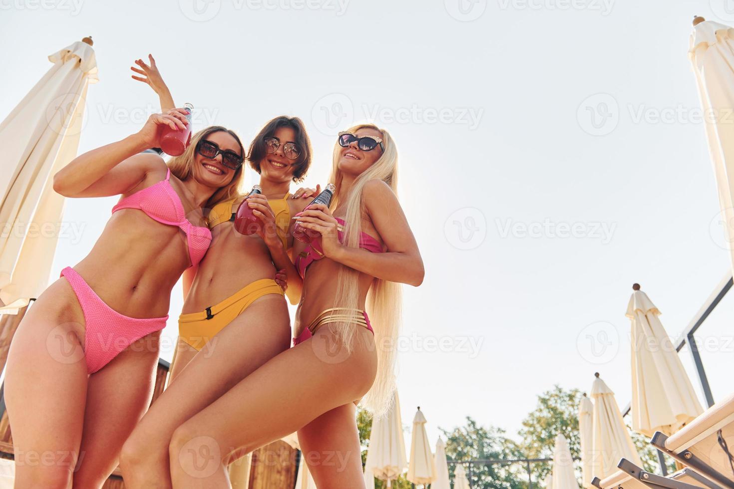 Women in swimsuits have fun outdoors together at summertime photo