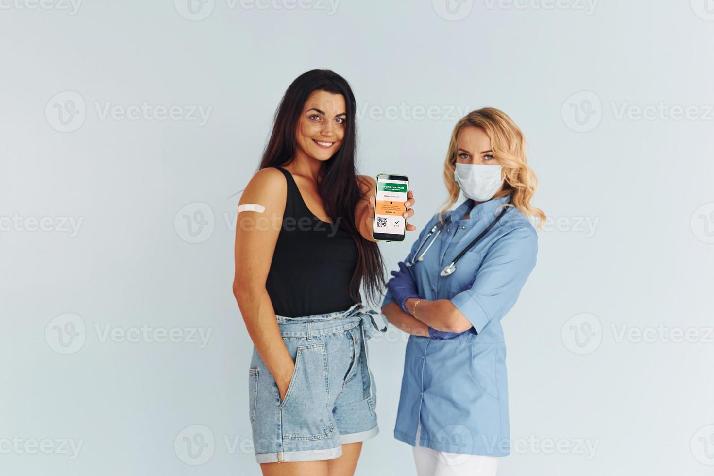 With digital passport. Doctor in uniform making vaccination to the patient photo